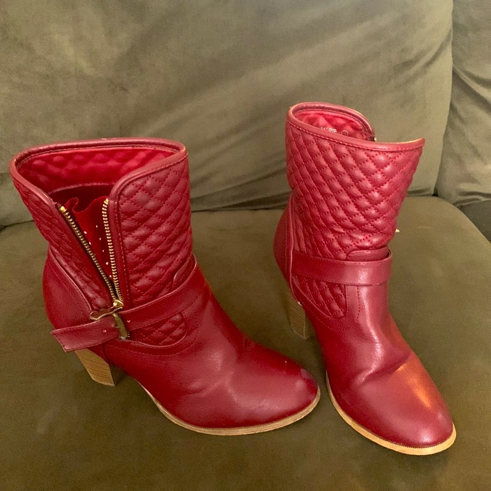 A red polished high heel boot with gold accessories
